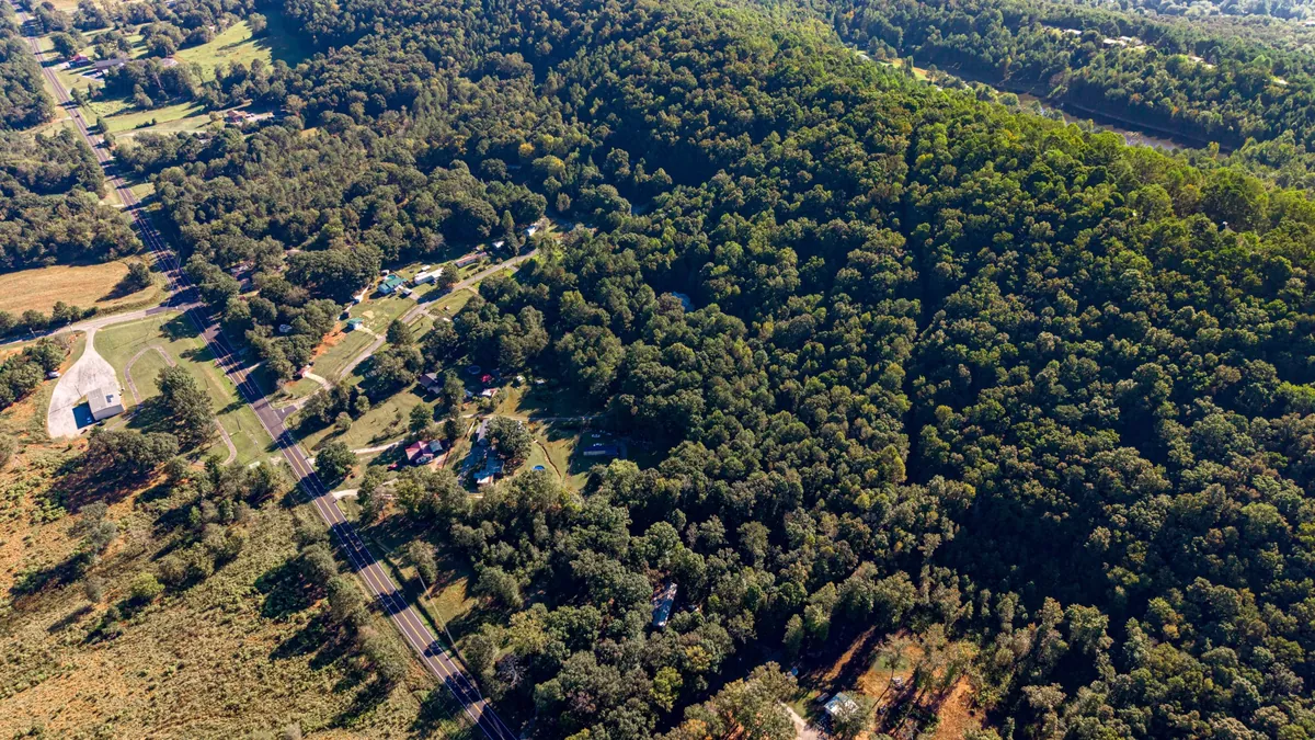 Oblique aerial showing the highway and the wooded land behind it